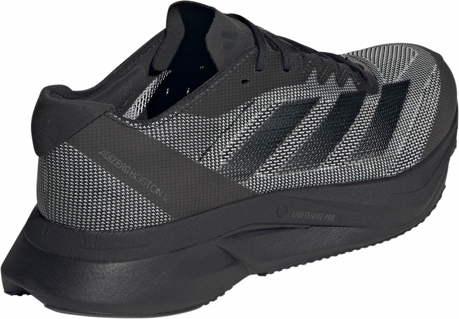 adidas Adizero Boston 12 Mens Running Shoes - Black running in a light rail station area shoes